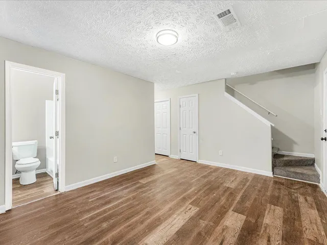 a view of a room with wooden floor and a bathroom