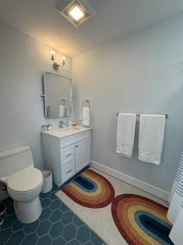 a bathroom with a toilet sink and mirror