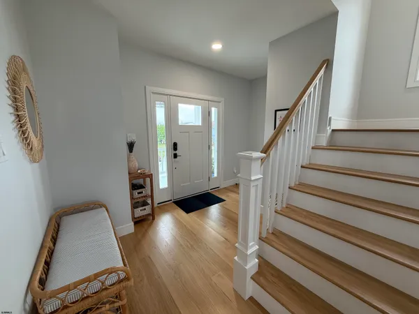 a view of a hallway with wooden floor and staircase