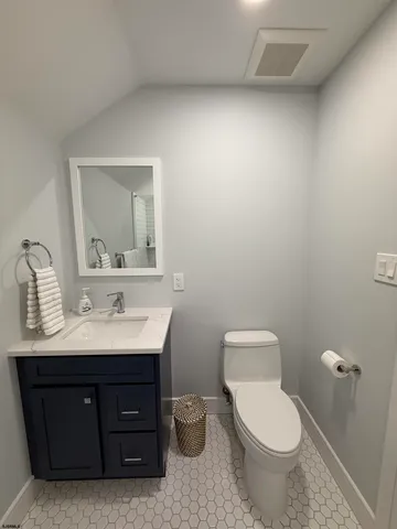 a bathroom with a toilet a sink and mirror