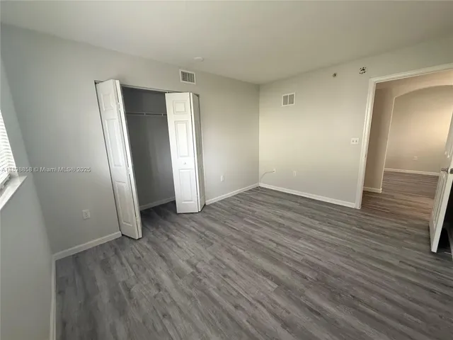 an empty room with wooden floor and entrance