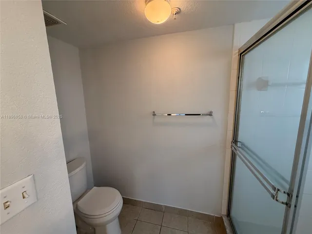 a bathroom with a granite countertop toilet and a sink