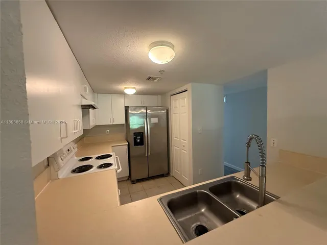 a kitchen that has a sink and a refrigerator