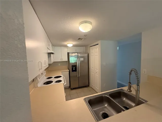 a kitchen that has a sink and a refrigerator