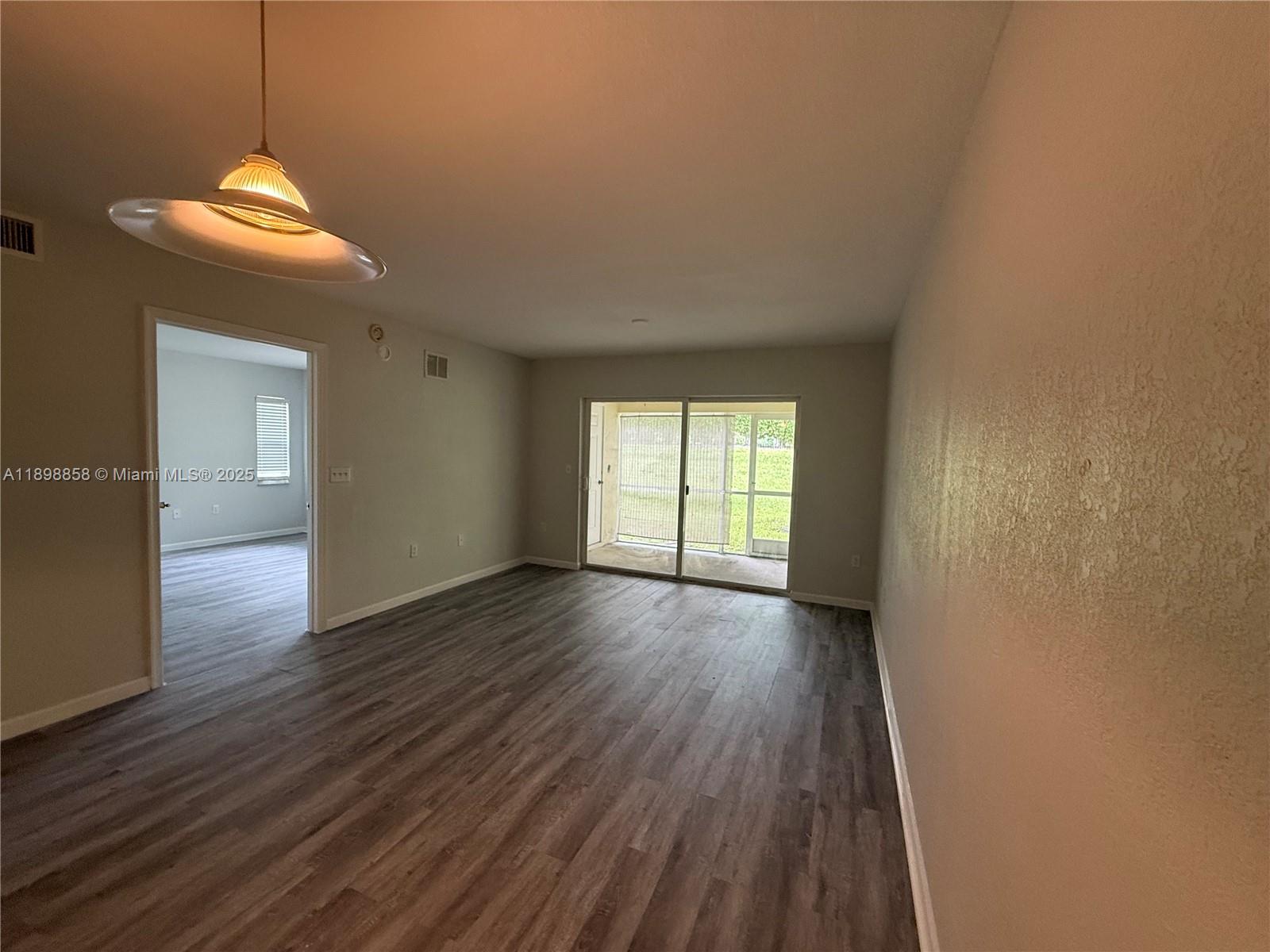 3452 Cypress Trail, Unit 101 West Palm Beach, FL 33417 - Photo 24 of 29 a view of an empty room with wooden floor and a window