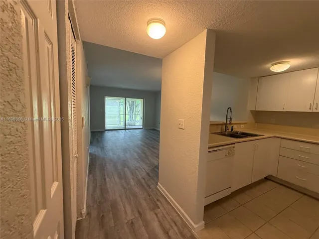 a kitchen with a sink and wooden floor
