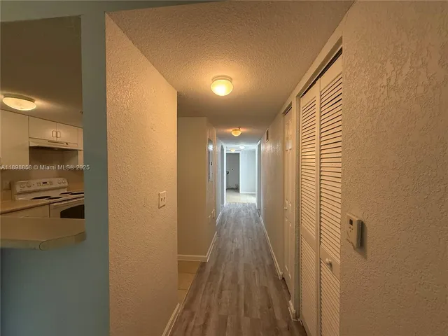 a view of a hallway with wooden floor