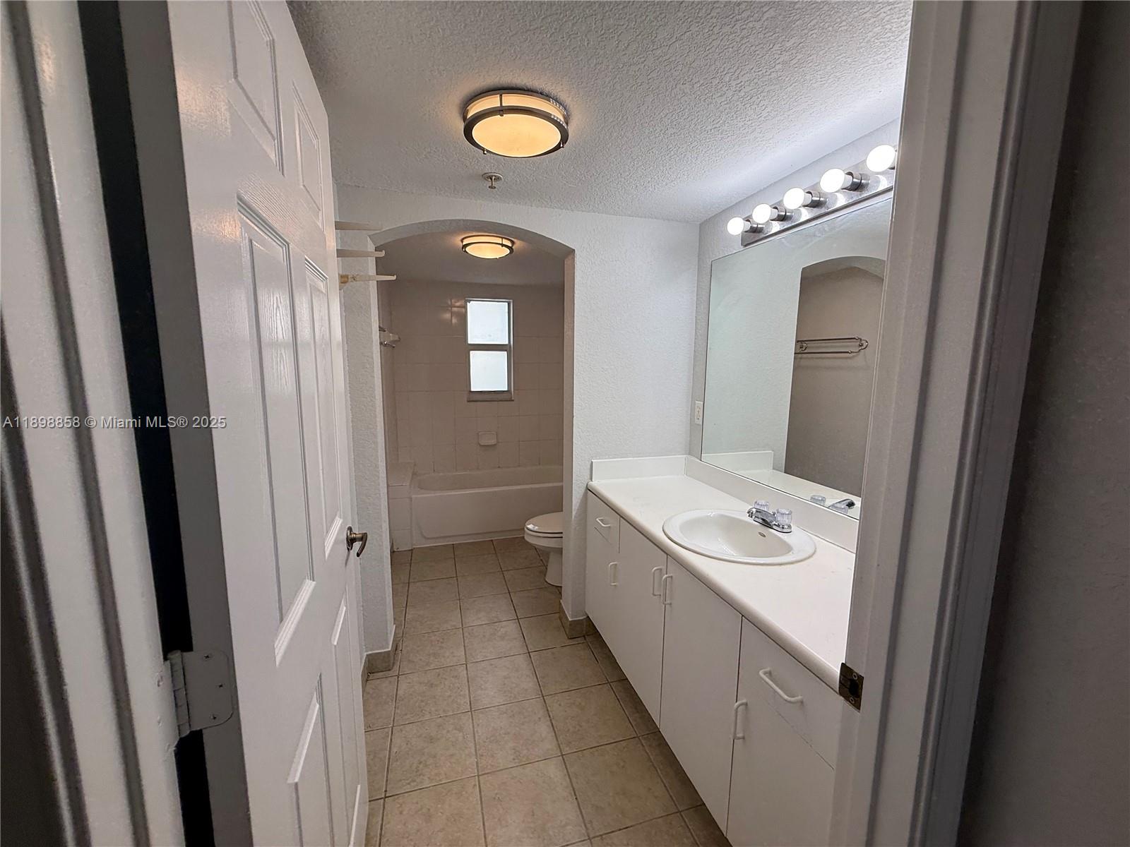 3452 Cypress Trail, Unit 101 West Palm Beach, FL 33417 - Photo 8 of 29 a bathroom with a sink a toilet and mirror