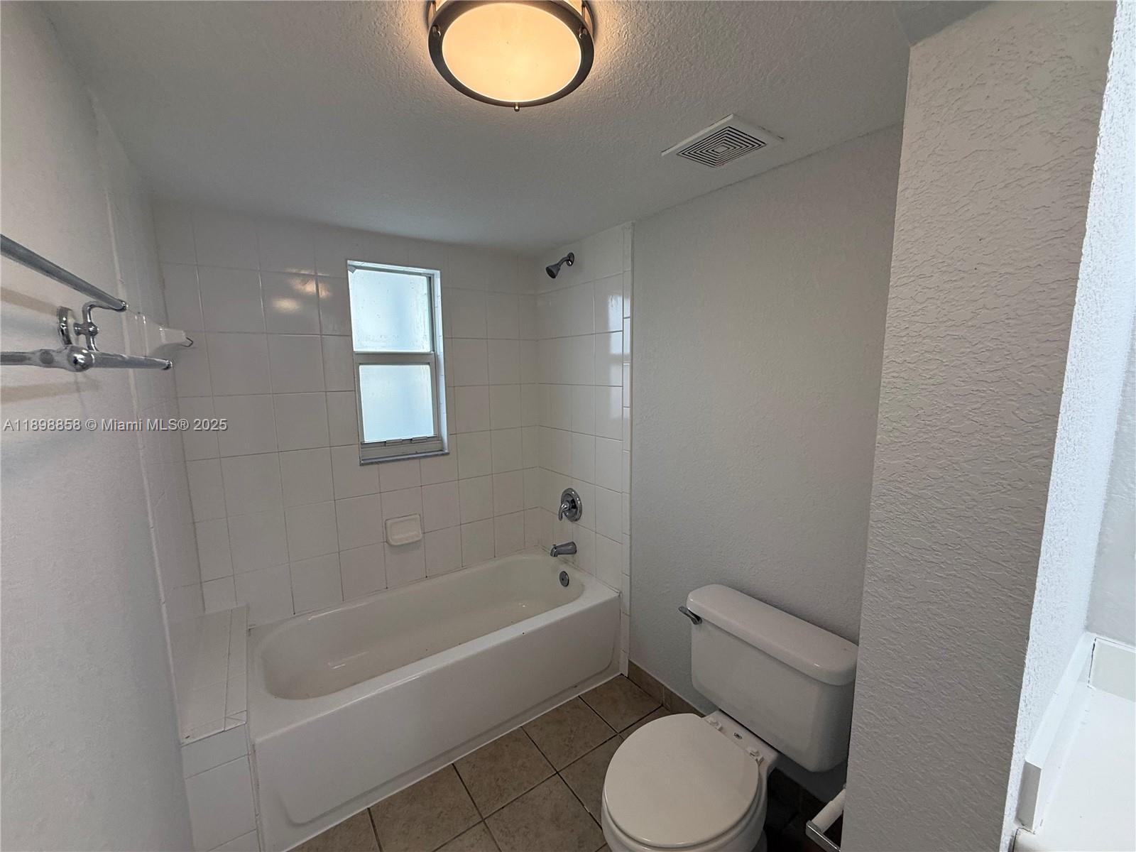 3452 Cypress Trail, Unit 101 West Palm Beach, FL 33417 - Photo 9 of 29 a bathroom with a toilet and a bathtub