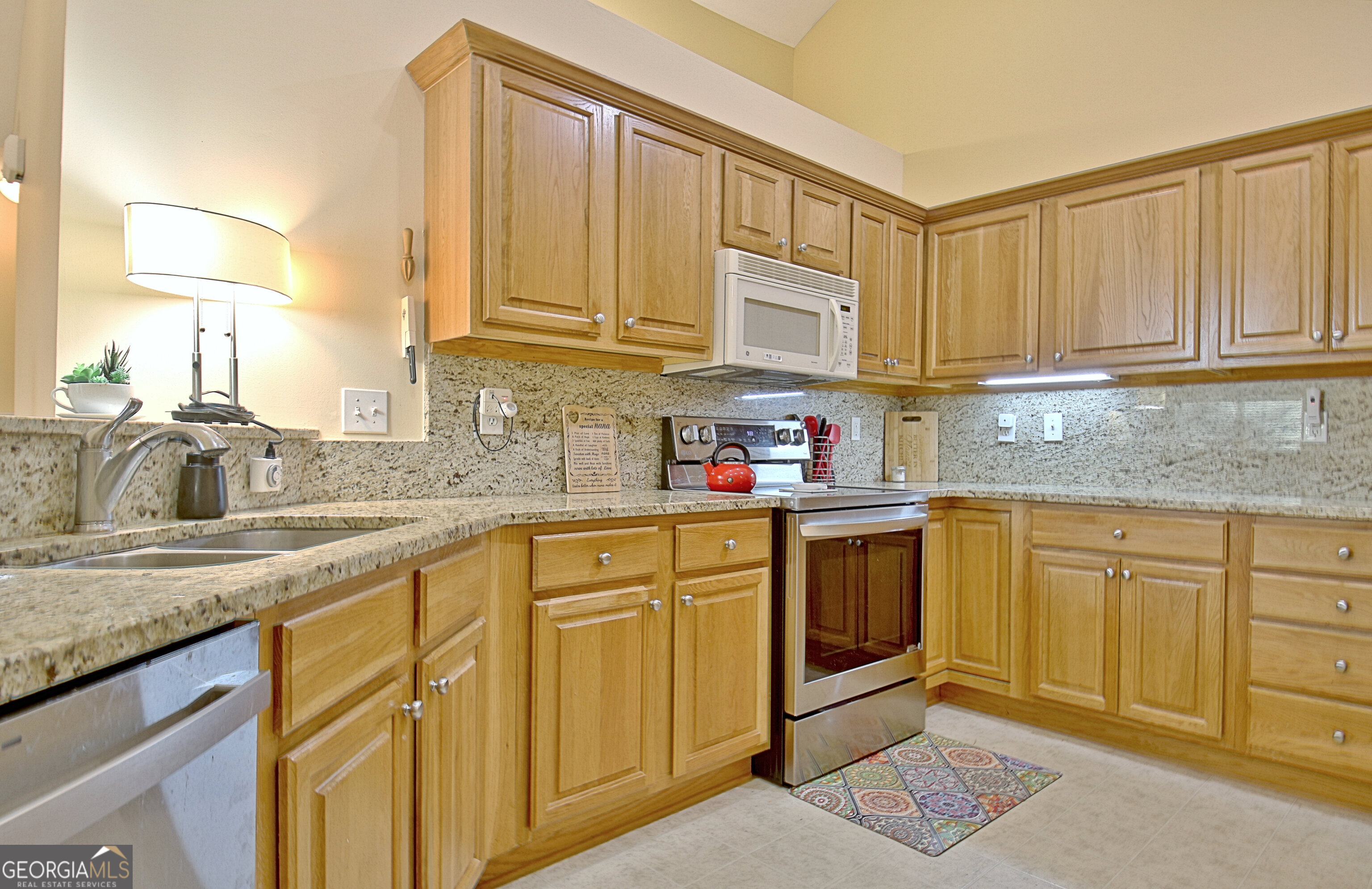 265 Rehobeth Way Fayetteville, GA 30214 - Photo 31 of 63 a kitchen with stainless steel appliances granite countertop a sink stove and cabinets
