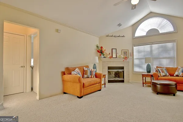 a living room with furniture a fireplace and a large mirror