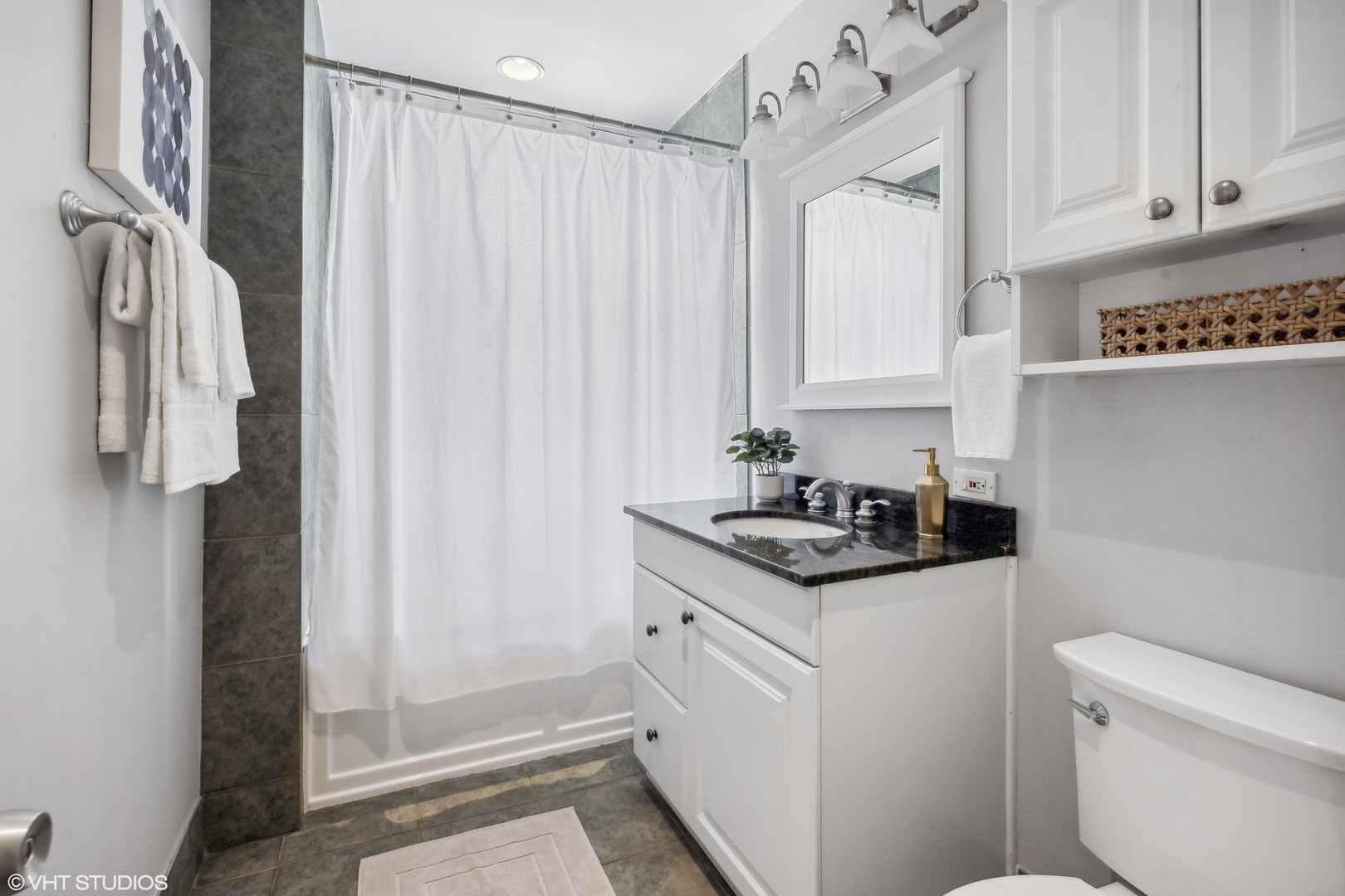 1050 West Byron Street, Unit 3W Chicago, IL 60613 - Photo 16 of 23 a bathroom with a granite countertop sink a toilet and a shower