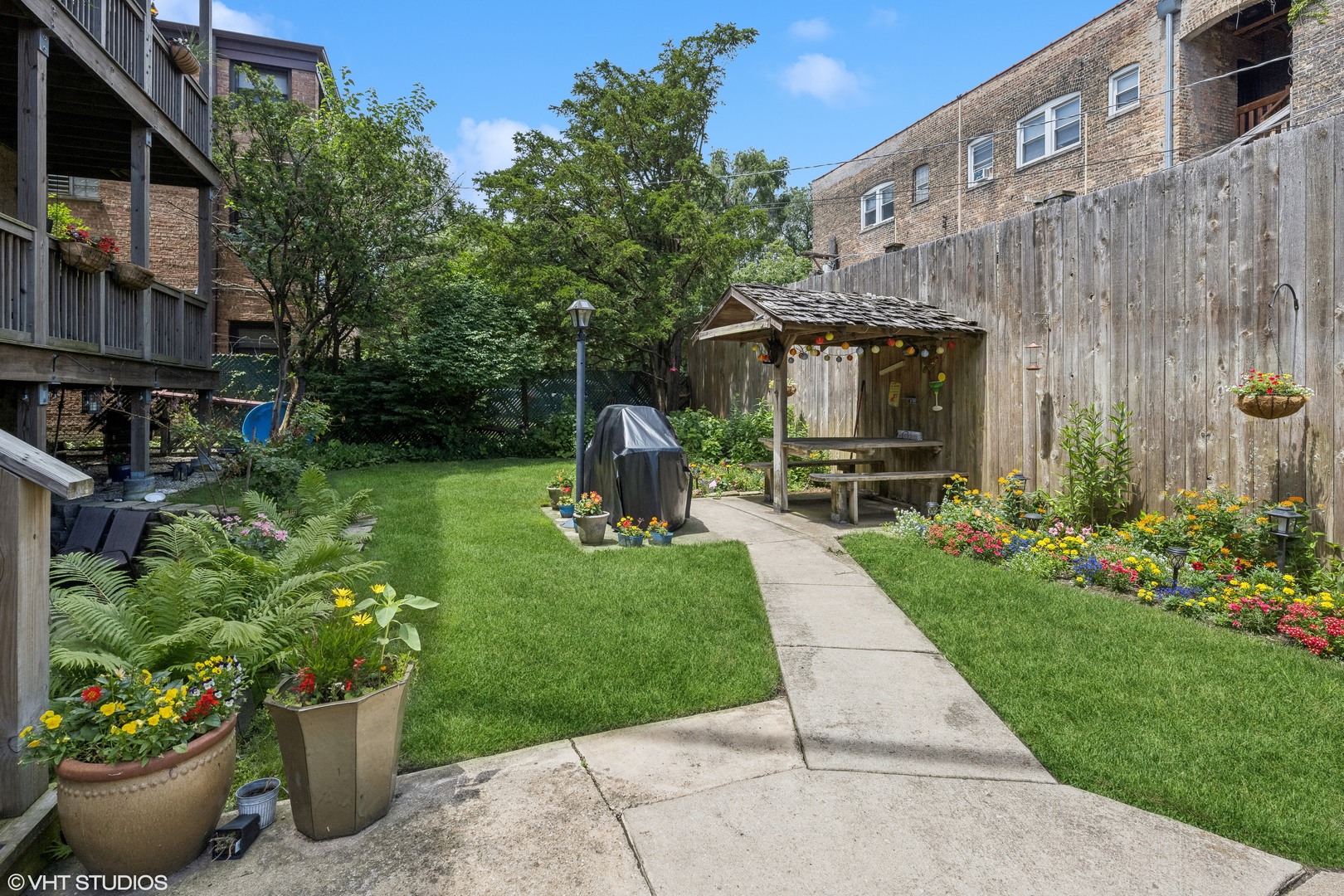 1050 West Byron Street, Unit 3W Chicago, IL 60613 - Photo 21 of 23 a front view of a house with a yard and potted plants