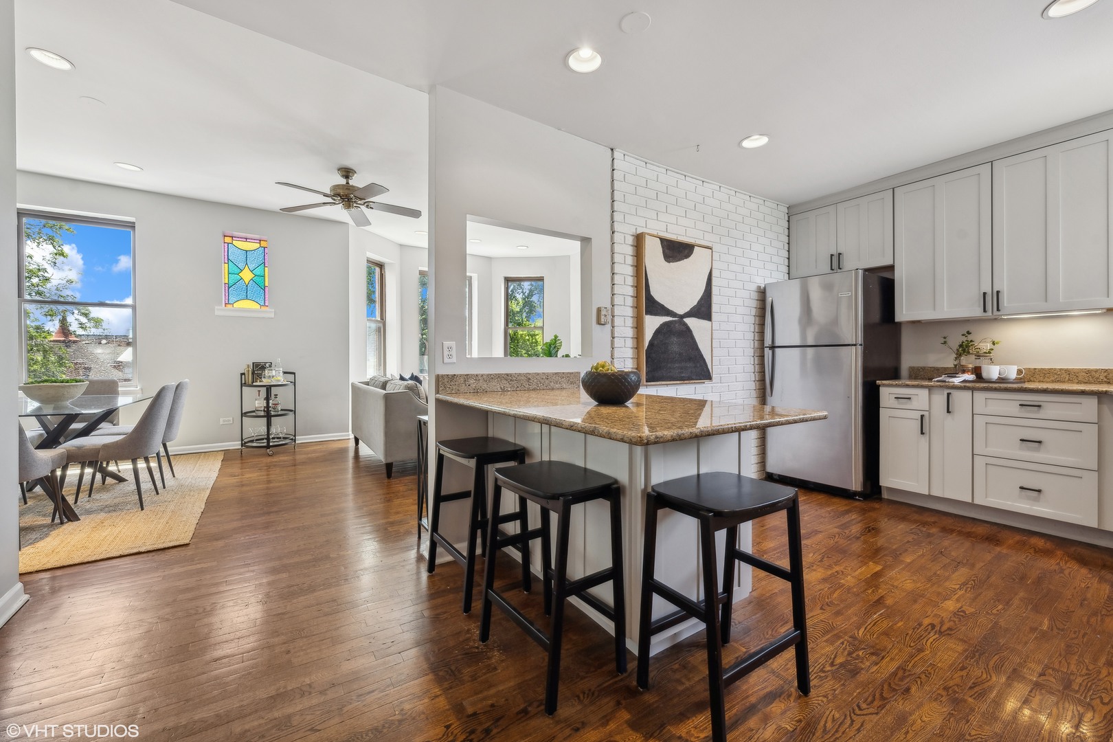 1050 West Byron Street, Unit 3W Chicago, IL 60613 - Photo 9 of 23 a kitchen with stainless steel appliances granite countertop a table chairs and a refrigerator