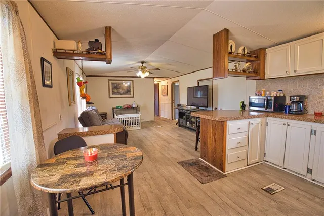 a living room with furniture a flat screen tv and kitchen view