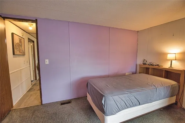 a bedroom with a bed and a refrigerator