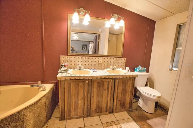 a bathroom with a sink a toilet a mirror and bathtub