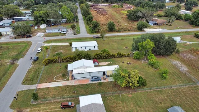 an aerial view of a house with a yard swimming pool and outdoor seating