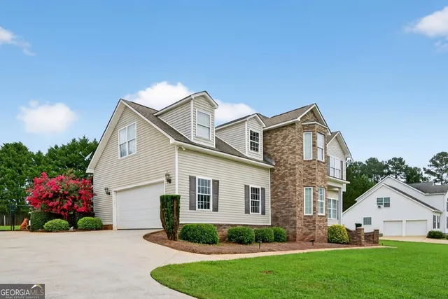 a view of a house with a yard and potted plants