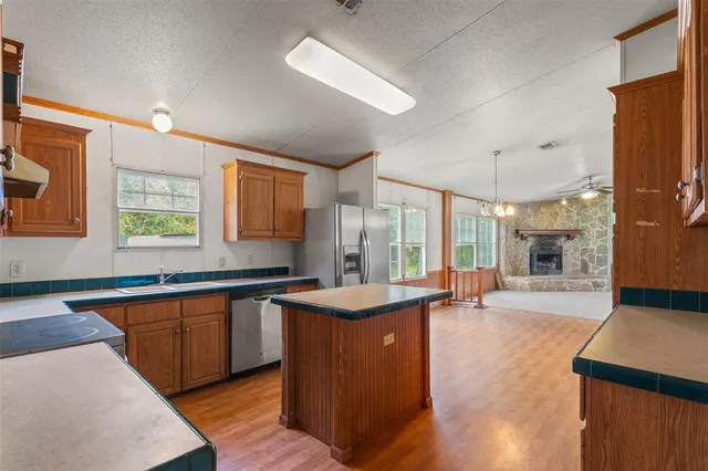 a large kitchen with kitchen island a sink wooden floor and counter space