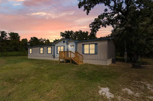 a view of a yard in front of a house with a large tree