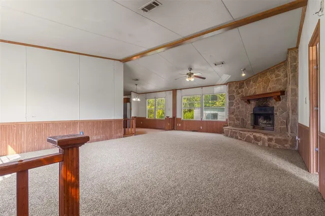 a view of an empty room with a fireplace and a window