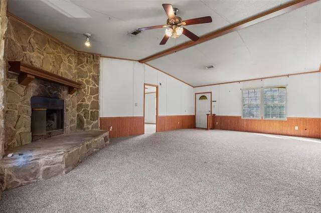 a view of empty room with fireplace and fan