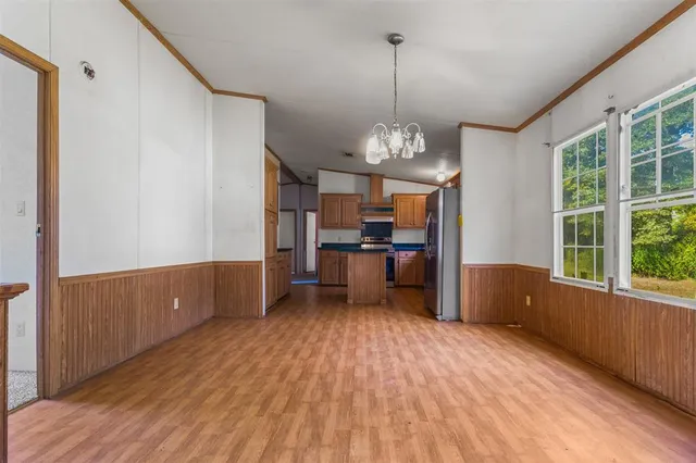 a view of a kitchen with wooden floor and stainless steel appliances