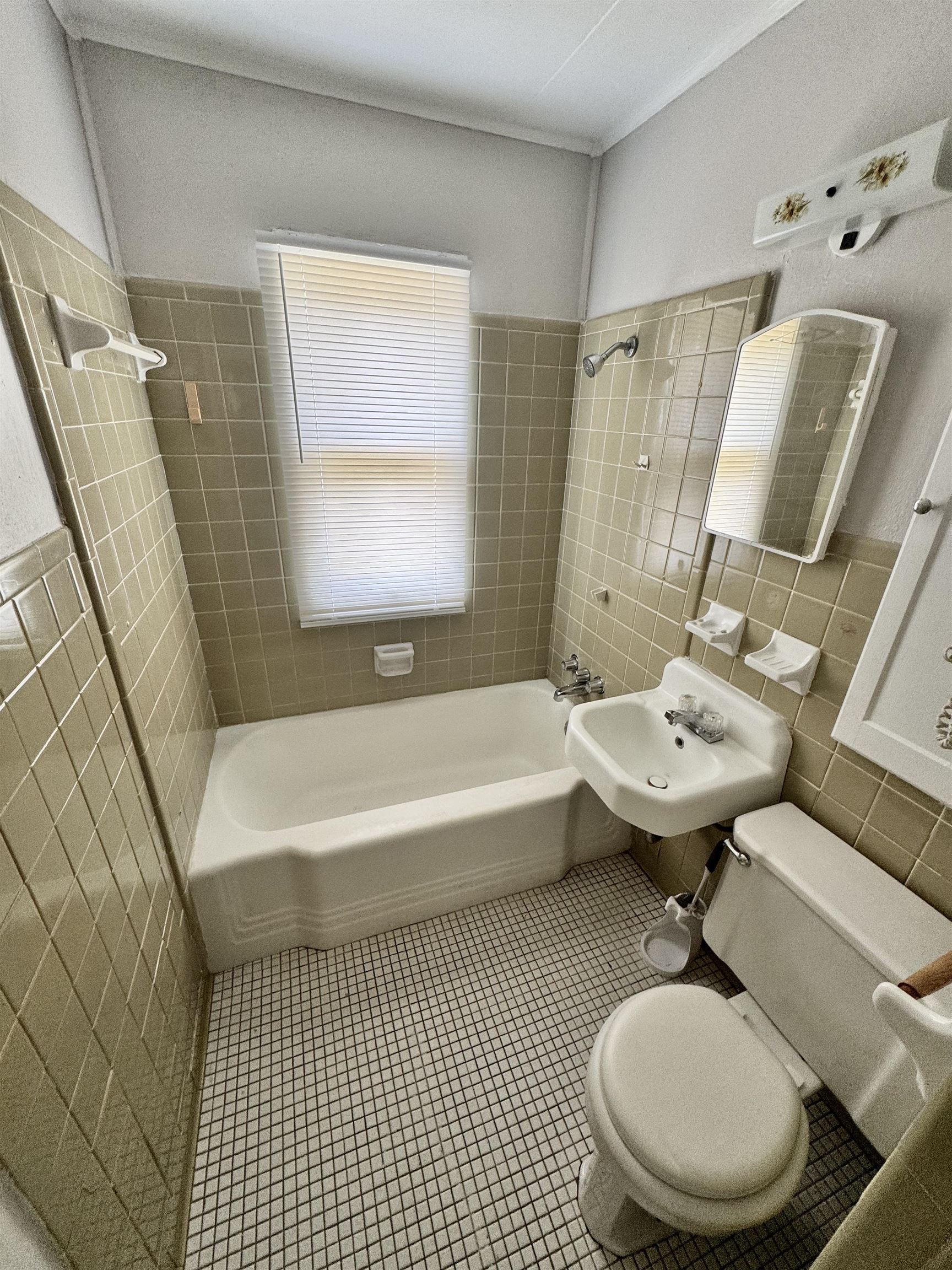 Bathroom with tile walls, bathtub / shower combination, and tile patterned floors