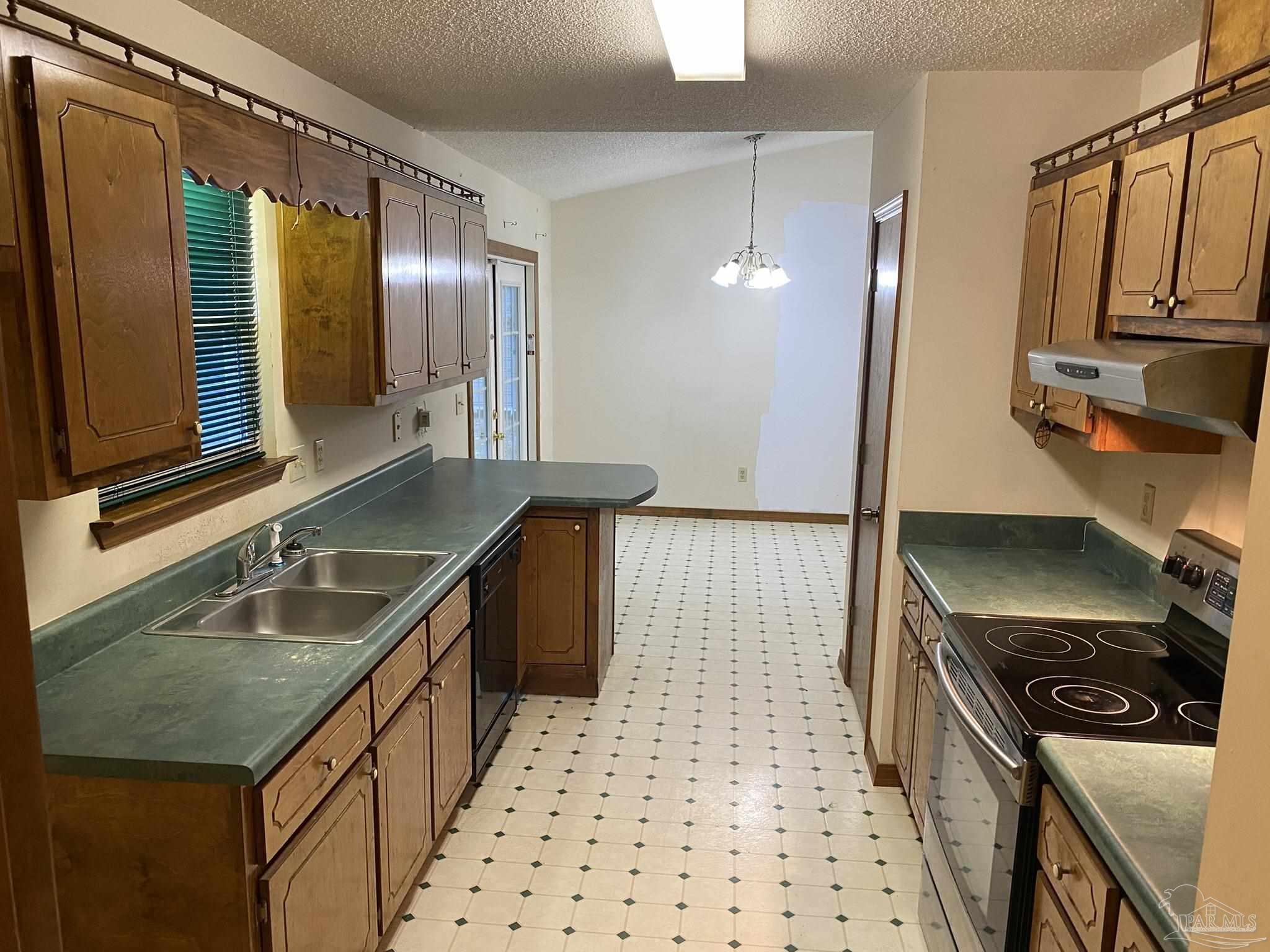 6333 Rice Street Milton, FL 32583 - Photo 11 of 19 a kitchen with granite countertop a sink stove and cabinets