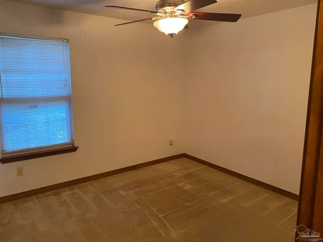 a view of a room with a fan and a window