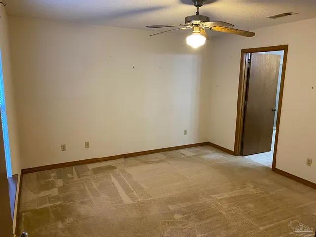 an empty room with closet and a chandelier fan