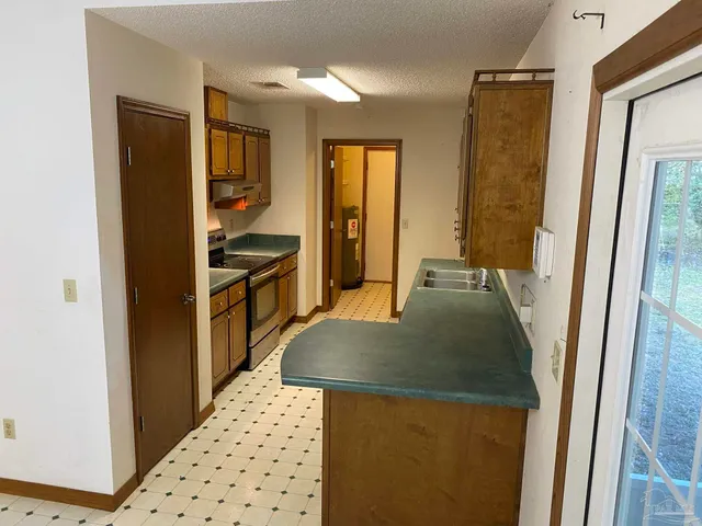 a kitchen with granite countertop a refrigerator and a sink