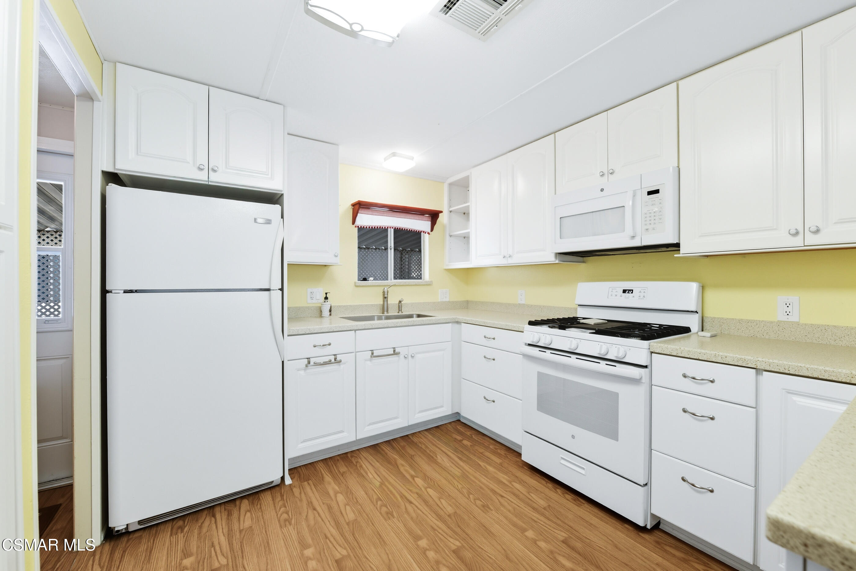 195 Tierra Rejada Road, Unit 178 Simi Valley, CA 93065 - Photo 12 of 49 a kitchen with cabinets appliances wooden floor and a window