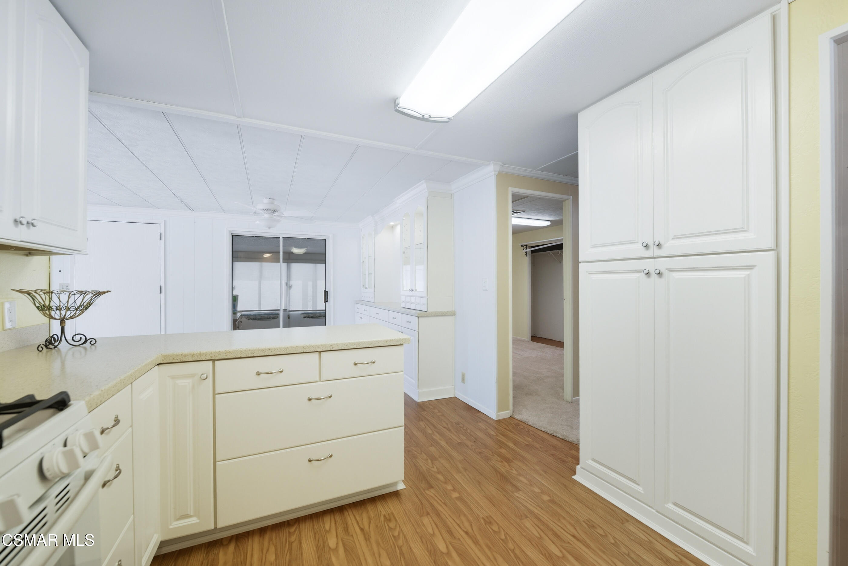195 Tierra Rejada Road, Unit 178 Simi Valley, CA 93065 - Photo 13 of 49 a kitchen with white cabinets and wooden floors