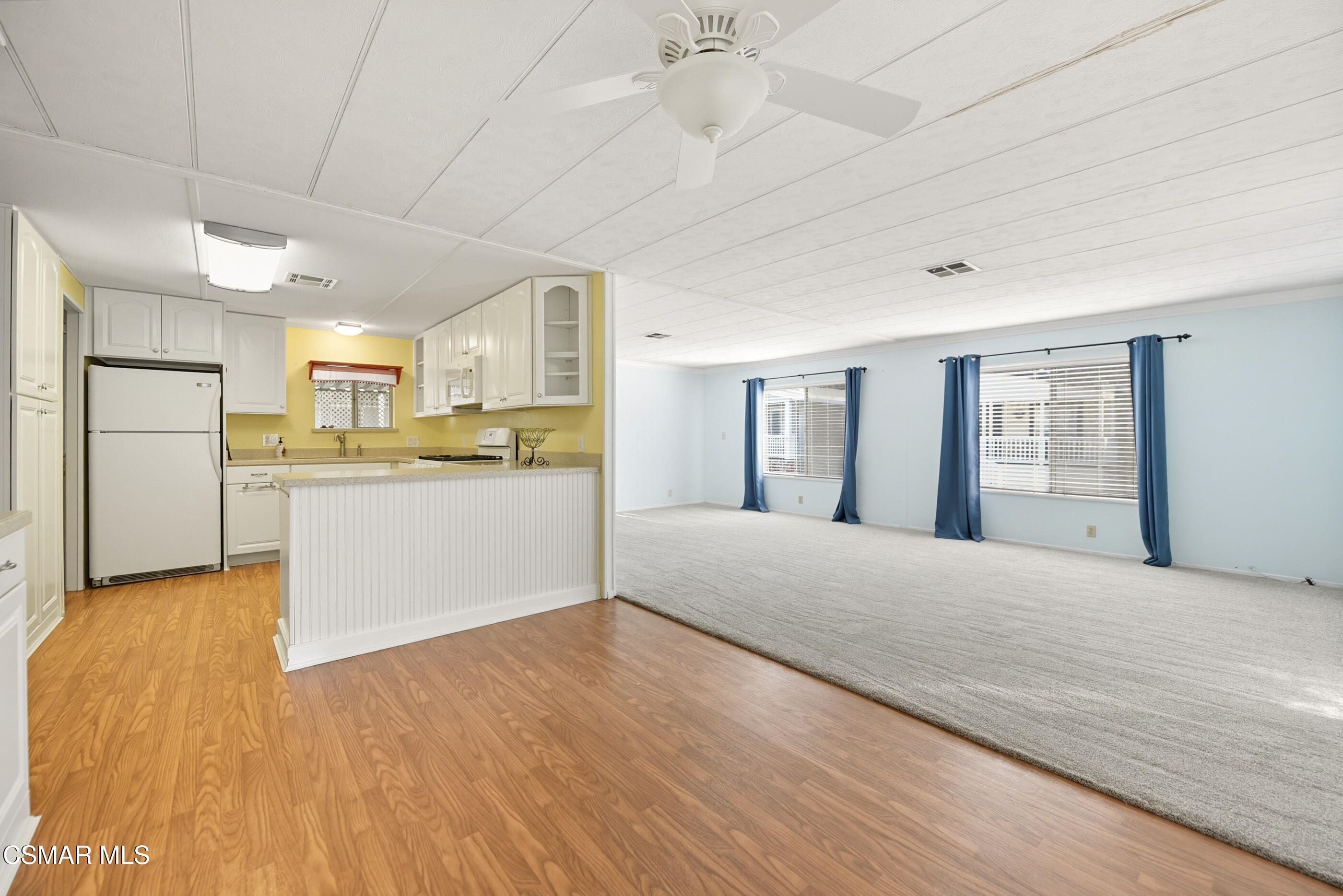 195 Tierra Rejada Road, Unit 178 Simi Valley, CA 93065 - Photo 8 of 49 a view of a kitchen with kitchen island a sink wooden floor and stainless steel appliances