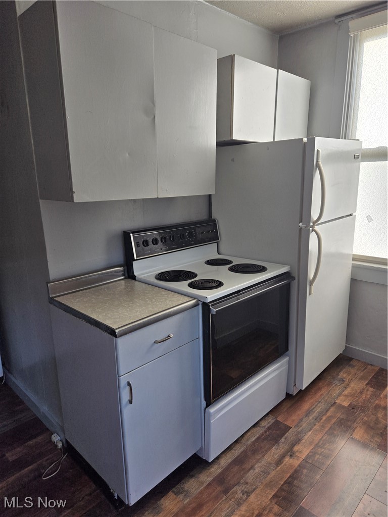 7968 River Styx Road Medina, OH 44256 - Photo 27 of 27 Kitchen featuring refrigerator, white range with electric cooktop, white cabinetry, dark hardwood / wood-style floors, and a textured ceiling