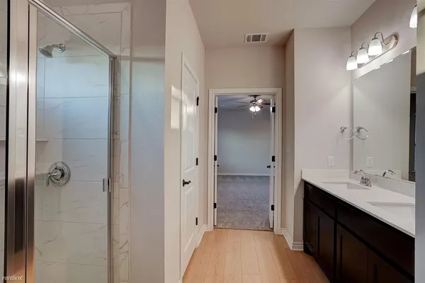 a bathroom with a double vanity sink a mirror and a shower