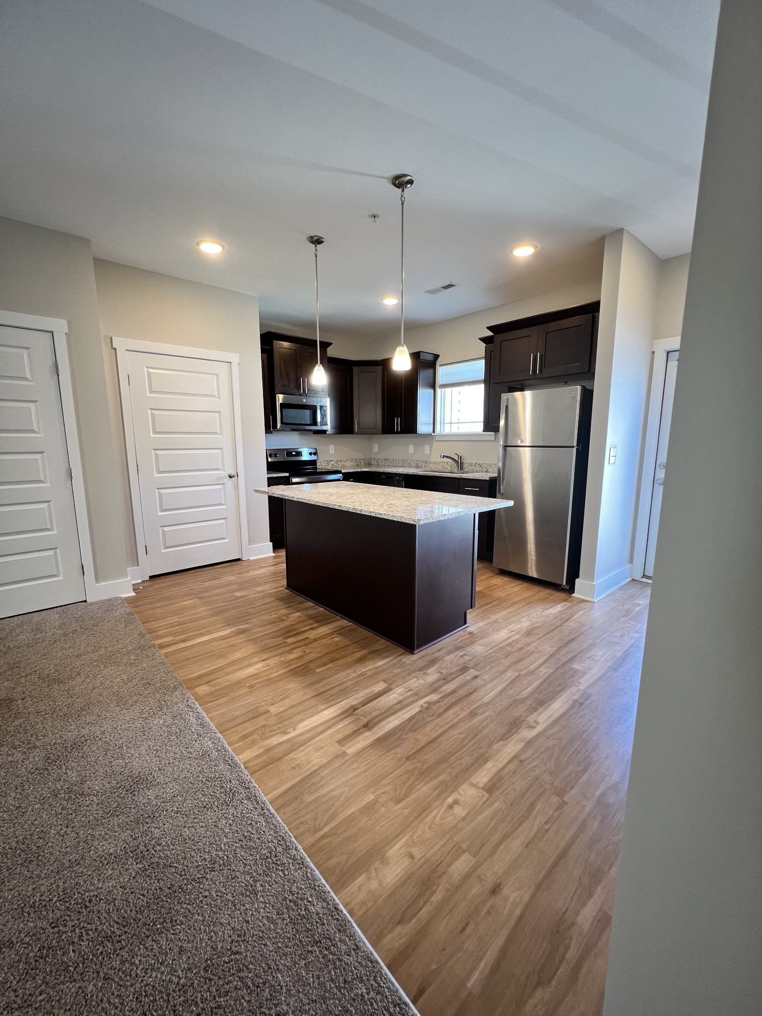 1056 Wells Way Spring Hill, TN 37174 - Photo 3 of 11 a large kitchen with stainless steel appliances kitchen island granite countertop a sink and a refrigerator