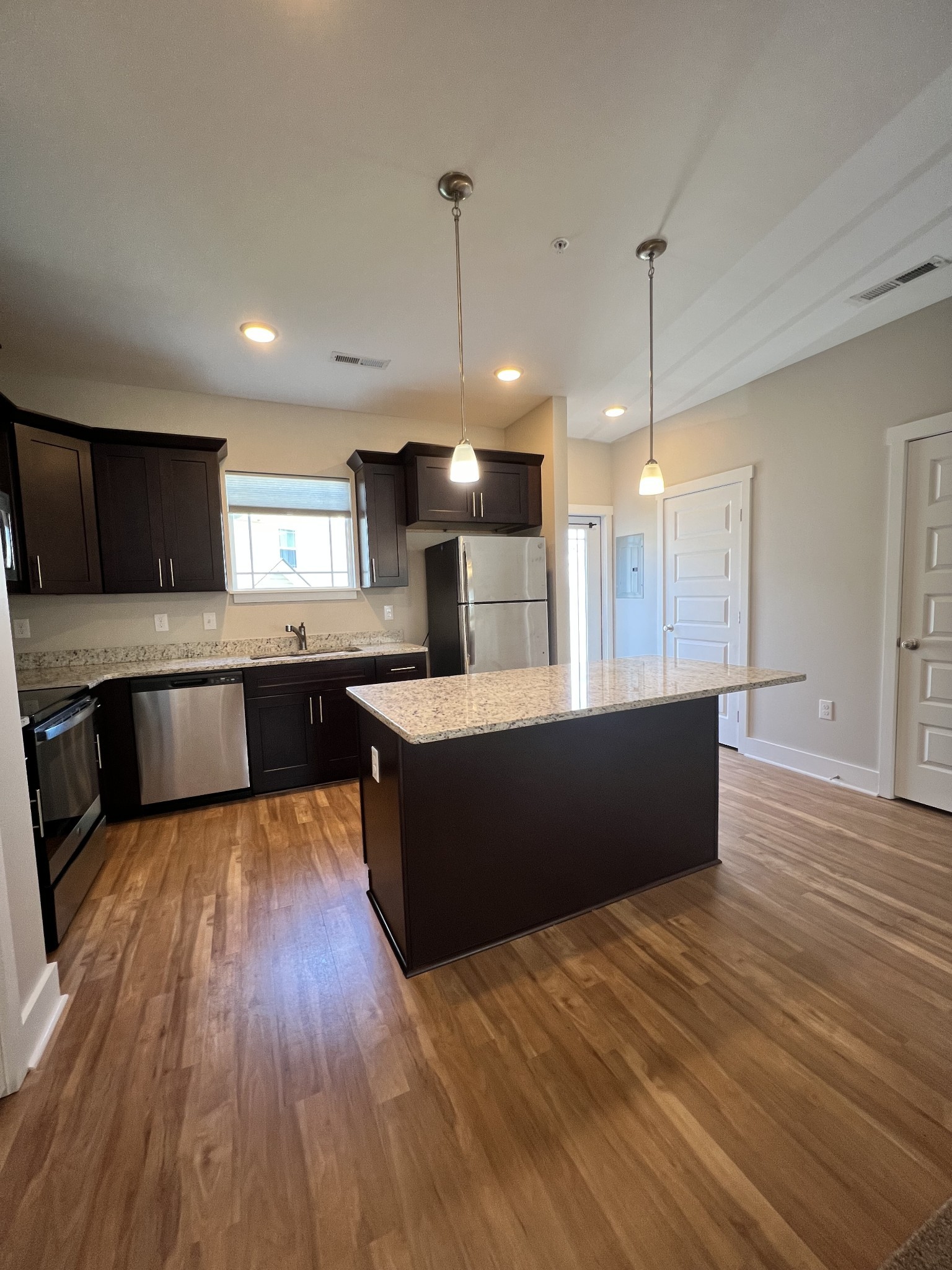 1056 Wells Way Spring Hill, TN 37174 - Photo 4 of 11 a large kitchen with wooden floors and stainless steel appliances