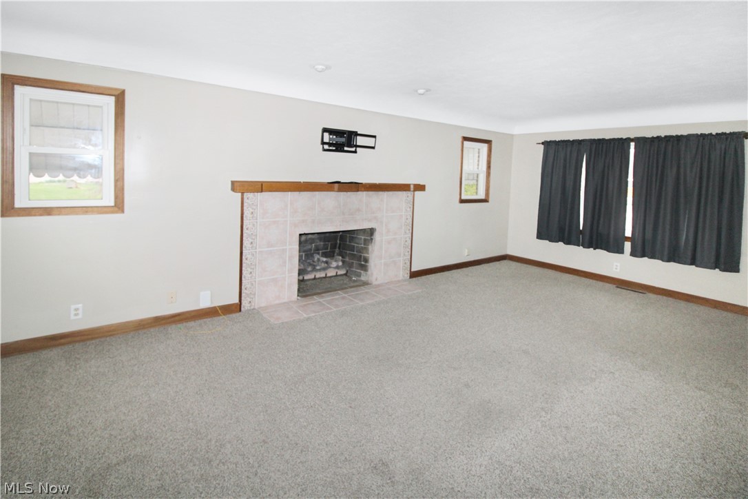 1036 West Fremont Road Port Clinton, OH 43452 - Photo 9 of 32 Unfurnished living room with a fireplace and light colored carpet