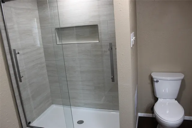 a bathroom with a toilet and a shower