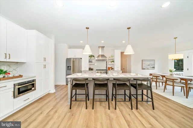 a view of a dining room and livingroom with furniture wooden floor a rug and a chandelier