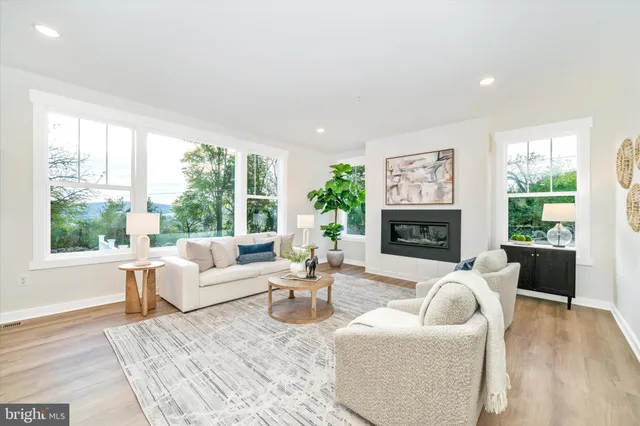 a living room with furniture a fireplace and a large window