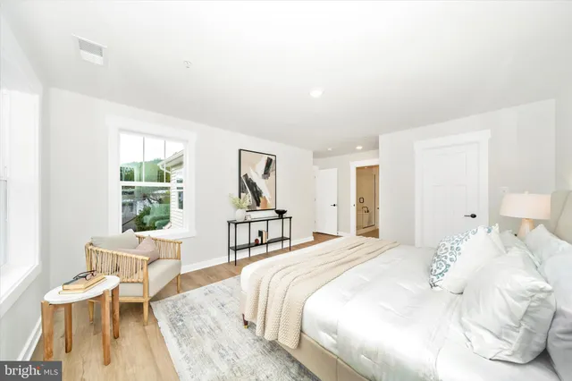 a bedroom with a bed and a large window