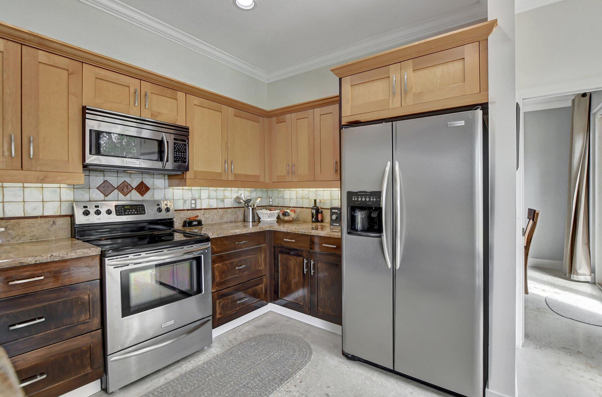 18498 East Covington Trace Boca Raton, FL 33498 - Photo 18 of 62 a kitchen with stainless steel appliances granite countertop a refrigerator a stove and a sink with wooden floor