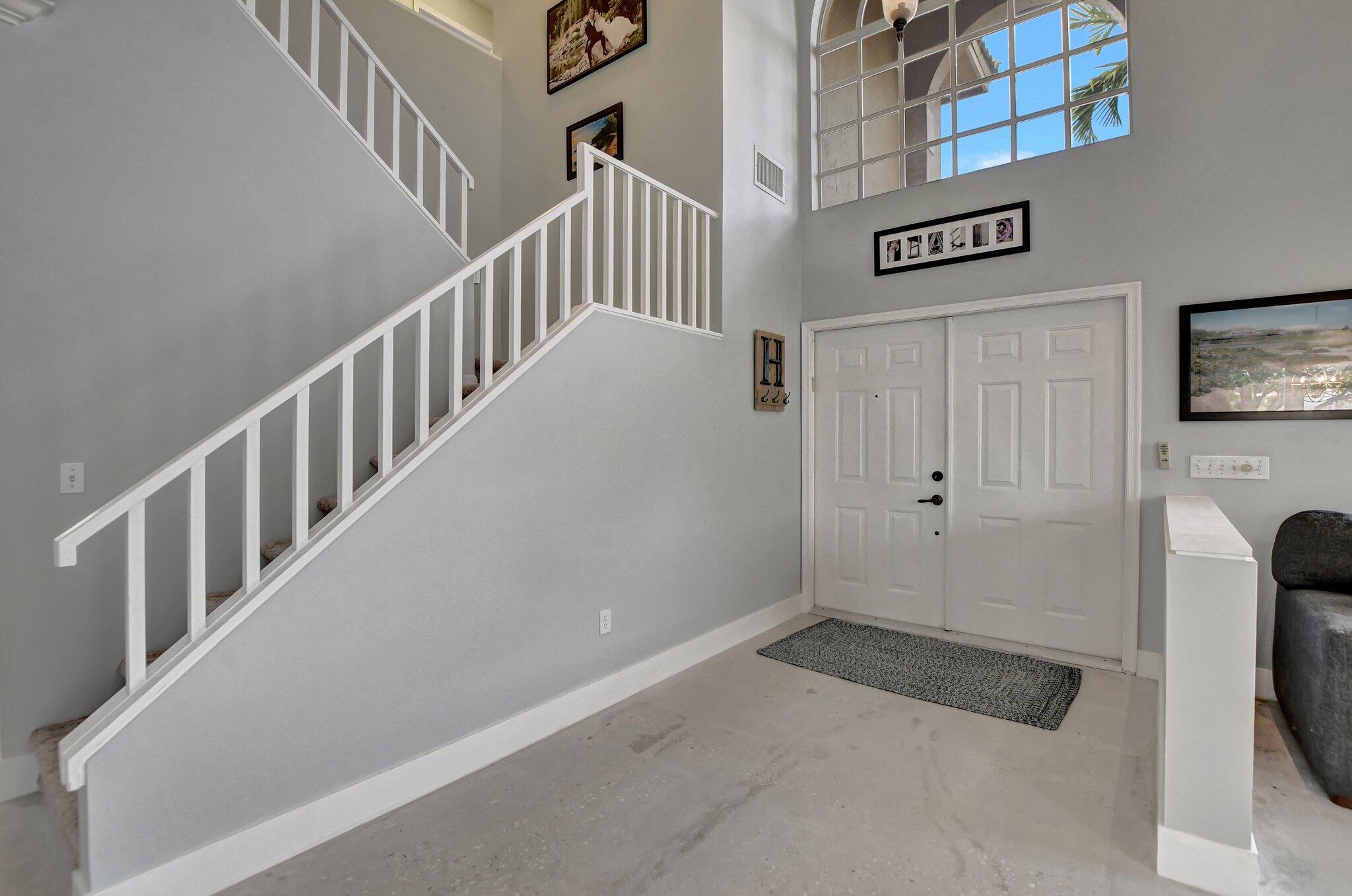 18498 East Covington Trace Boca Raton, FL 33498 - Photo 5 of 62 a view of staircase with lots of frames on wall and a flat screen tv