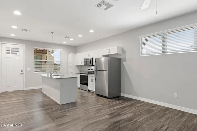 a kitchen with stainless steel appliances granite countertop a refrigerator and a stove top oven