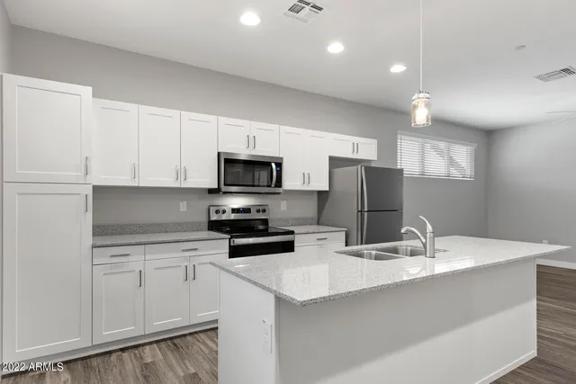 a kitchen with stainless steel appliances a sink a stove a microwave and cabinets