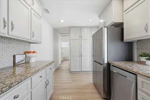 a kitchen with stainless steel appliances granite countertop a sink refrigerator and cabinets
